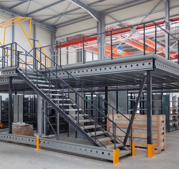 Single-level metal mezzanine storage platform with staircase and lock gate in a warehouse